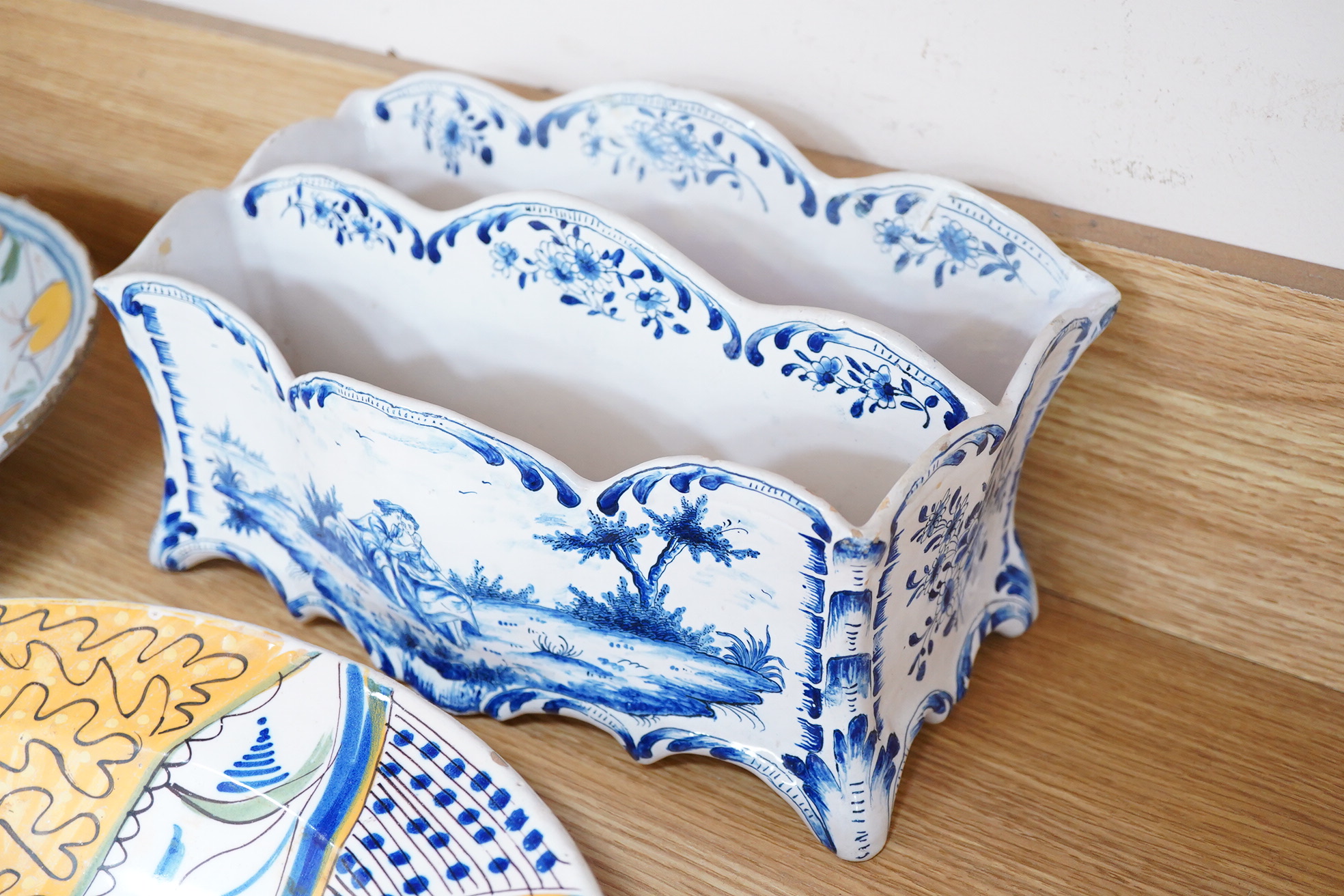 Two 18th century Delft polychrome chargers, five other faience chargers, a rectangular 19th century French faience dish and a blue and white letter rack